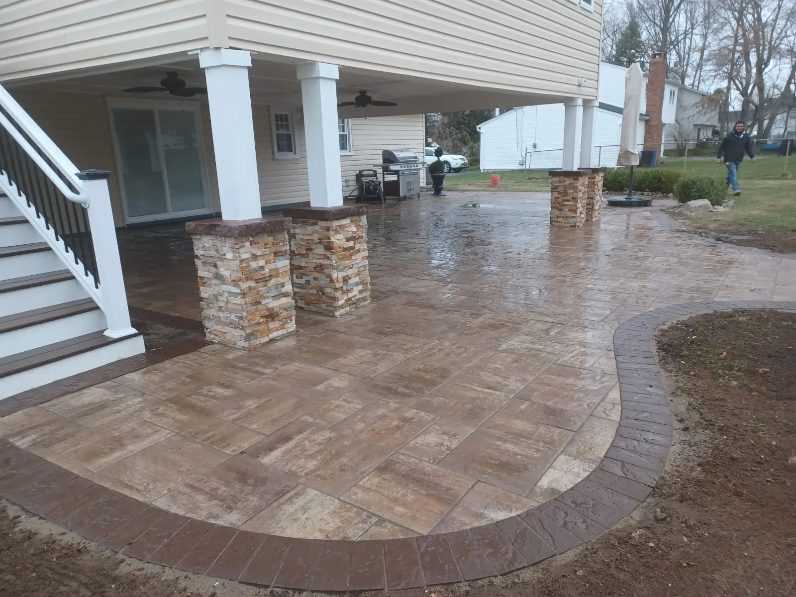 Covered backyard paver patio with stacked-stone column bases, built by New Jersey Pavers