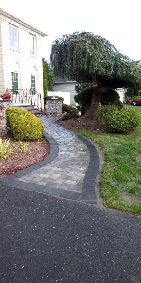 Curved paver walkway connecting a home and its landscape