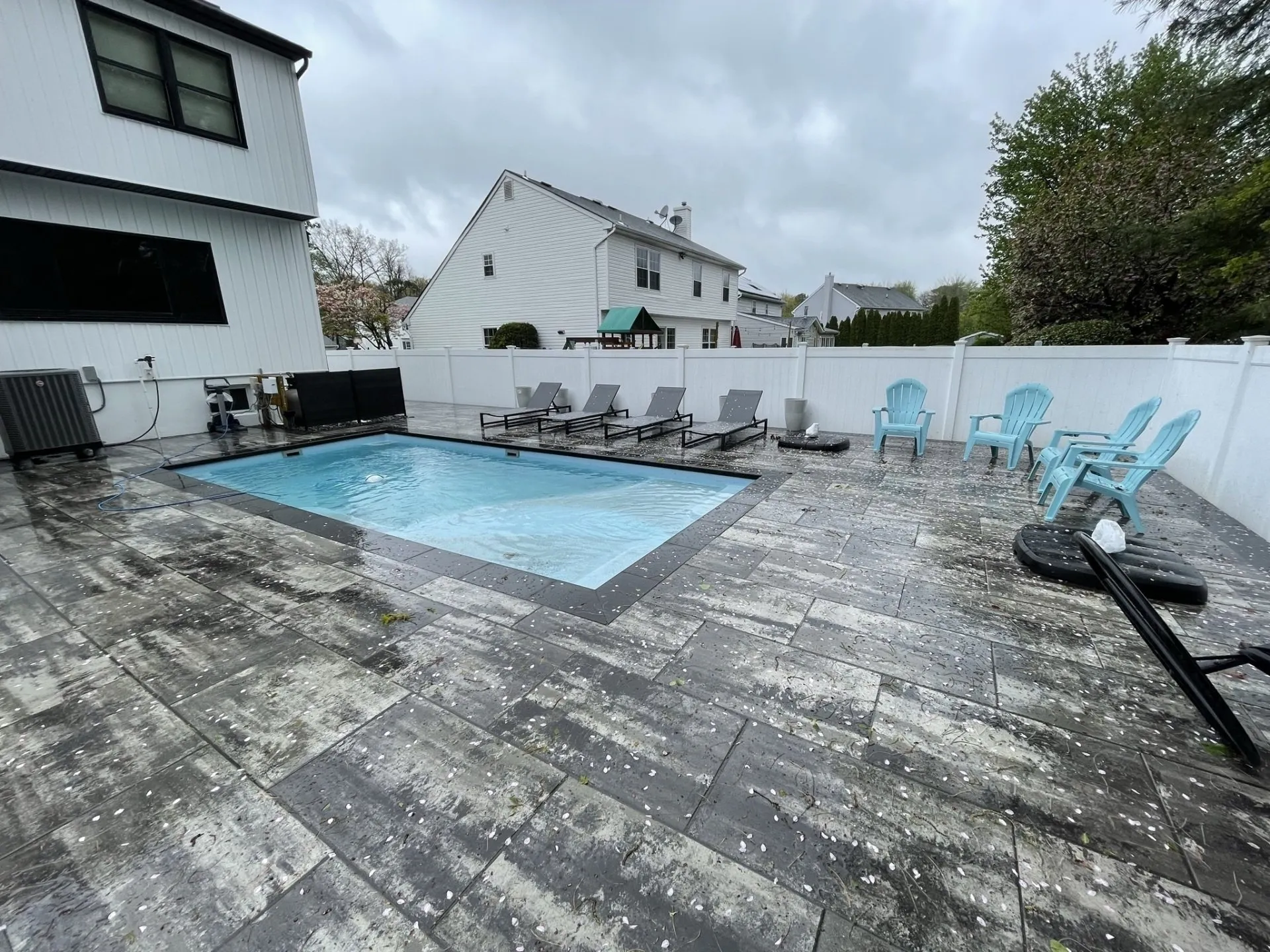 Gray paver pool deck with dark coping and border details, built by New Jersey Pavers