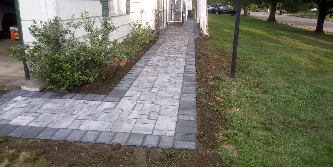 Gray pavers with a darker border beside a house