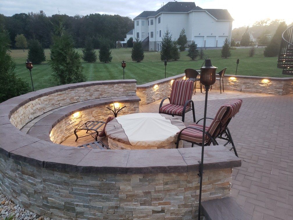 Lighted sitting wall around a paver patio and firepit