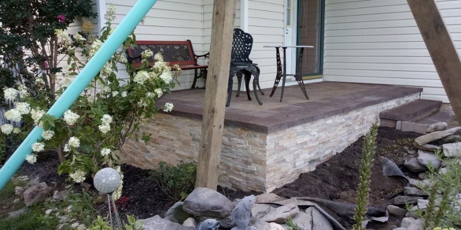Raised stone patio landing with a retaining wall