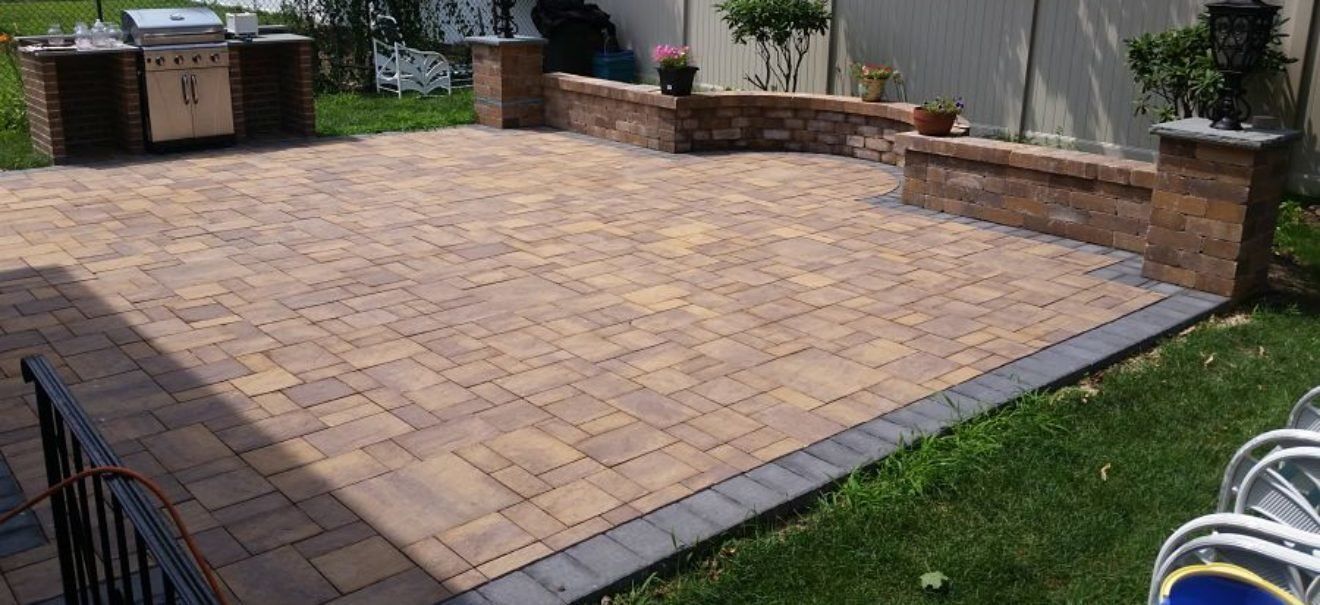 Paver patio framed by a sitting wall