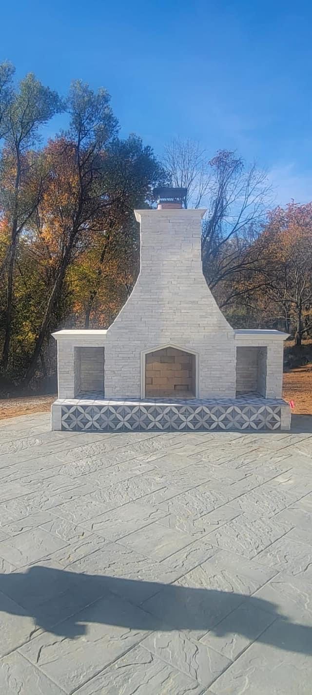 Outdoor stone fireplace beside a patio