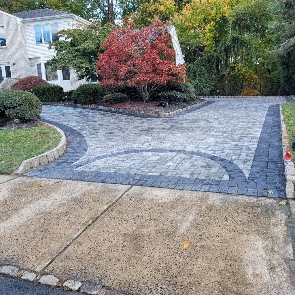 Curving paver driveway with a contrasting border and landscaped island